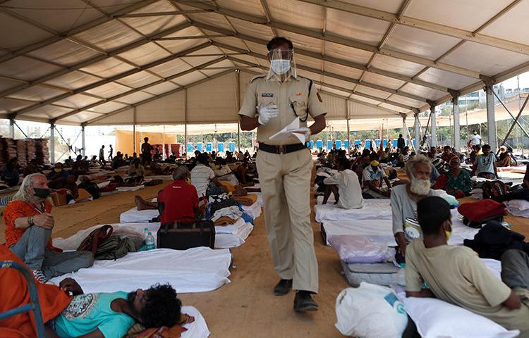 A police officer walks inside a shelter set up for migrants in Mumbai, India, April 6, 2020. The Indian Supreme Court recently passed a directive in response to alleged fake news that prompted migration in the country. (Reuters/Francis Mascarenhas)