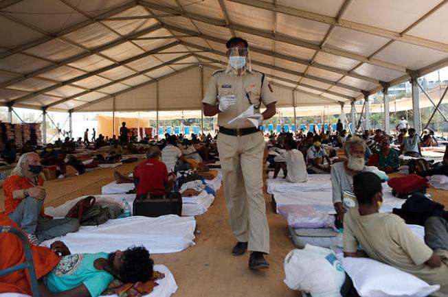 A police officer walks inside a shelter set up for migrants in Mumbai, India, April 6, 2020. The Indian Supreme Court recently passed a directive in response to alleged fake news that prompted migration in the country. (Reuters/Francis Mascarenhas)