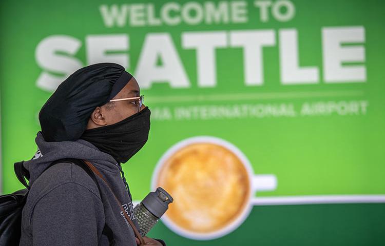 A passenger walks through Seattle-Tacoma International Airport on March 15, 2020, in Seattle, Washington. CPJ recently spoke with journalists covering the COVID-19 pandemic in Seattle. (John Moore/Getty Images via AFP)