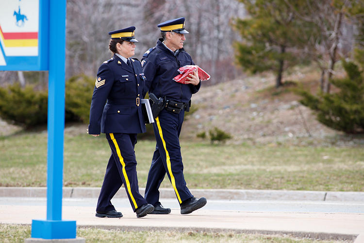 Two Royal Canadian Mounted Police (RCMP) officers leave the Nova Scotia RCMP Headquarters in Dartmouth, Nova Scotia, on April 20. Journalists in the province have struggled to cover a mass shooting due to COVID-19 containment measures. (Reuters/John Morris)