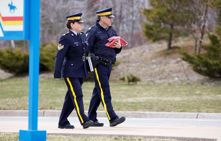 Two Royal Canadian Mounted Police (RCMP) officers leave the Nova Scotia RCMP Headquarters in Dartmouth, Nova Scotia, on April 20. Journalists in the province have struggled to cover a mass shooting due to COVID-19 containment measures. (Reuters/John Morris)
