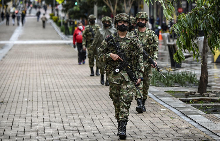 Soldados colombianos que llevan mascarillas como medida preventiva contra la propagación del COVID-19 se despliegan en la plaza Simón Bolívar en Bogotá el 21 de abril de 2020. Un informe del semanario colombiano Semana publicado el 1 de mayo reveló que oficiales de la inteligencia militar colombiana había espiado a periodistas locales e internacionales. (AFP/Juan Barreto)