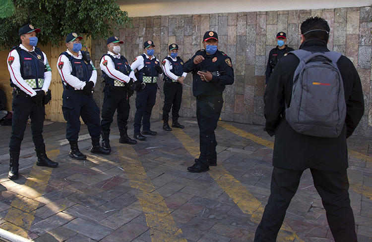 Police officers are seen in Mexico City on May 16, 2020. An unidentified man recently threatened to bomb the Mexico City offices of the Reforma newspaper. (AFP/Claudio Cruz)