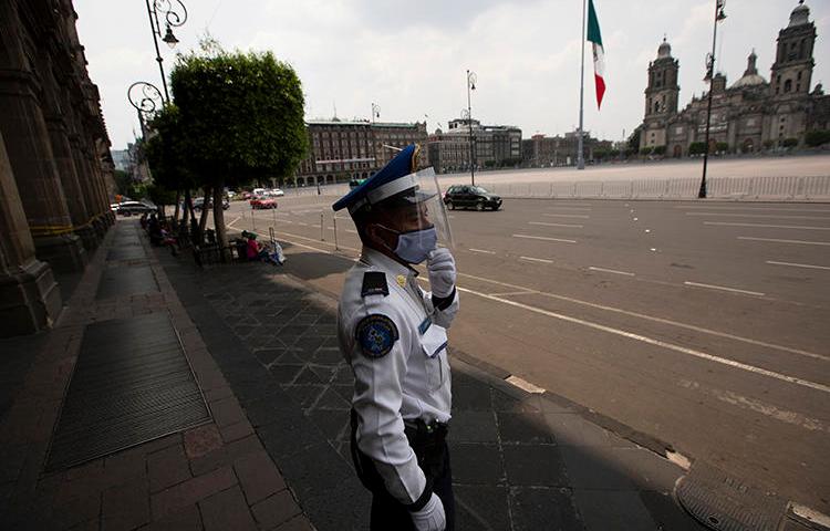 A police officer is seen in Mexico City on April 25, 2020. The Mexican Interior Secretariat recently threatened two news companies over their coronavirus coverage. (AP/Fernando Llano)