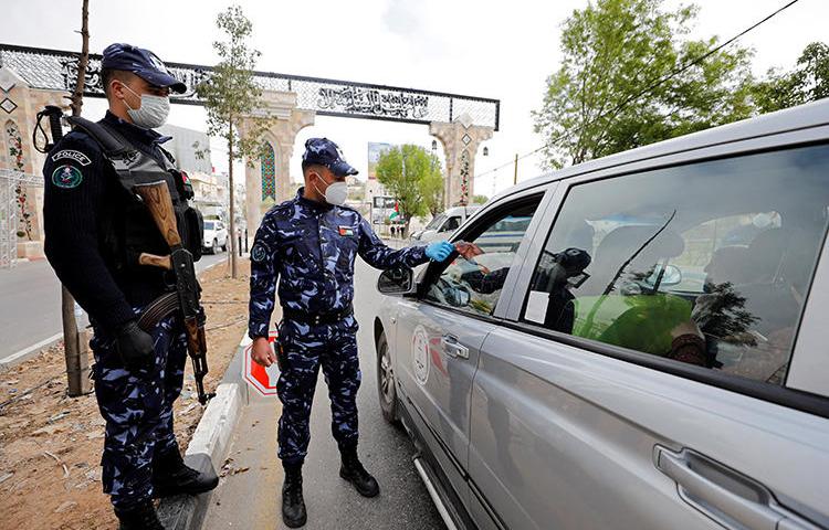 Palestinian police officers are seen in Hebron, in the West Bank, on April 7, 2020. Police recently attacked and arrested journalist Anas Hawari at a checkpoint. (Reuters/Mussa Qawasma)