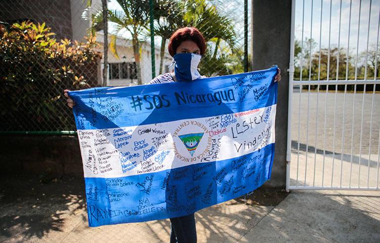 A protester holds a national flag during a demonstration against President Daniel Ortega's government in Managua, Nicaragua, on February 25, 2020. YouTube has censored independent Nicaraguan news outlets after copyright complaints from Ortega-owned media. (Reuters/Oswaldo Rivas)