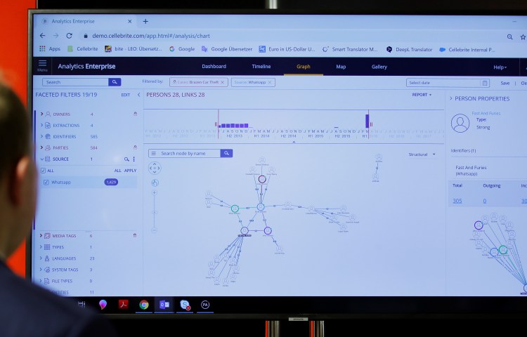 A man examines a large Cellebrite demo screen showing data analysis.