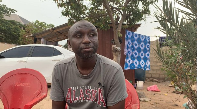 Kamilu Ibrahim Tahidu, a brother of slain journalist Ahmed Hussien-Suale Divela, sits outside their family home in Accra, Ghana. (Photo: Jonathan Rozen/CPJ)