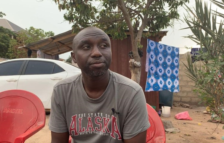 Kamilu Ibrahim Tahidu, a brother of slain journalist Ahmed Hussien-Suale Divela, sits outside their family home in Accra, Ghana. (Photo: Jonathan Rozen/CPJ)