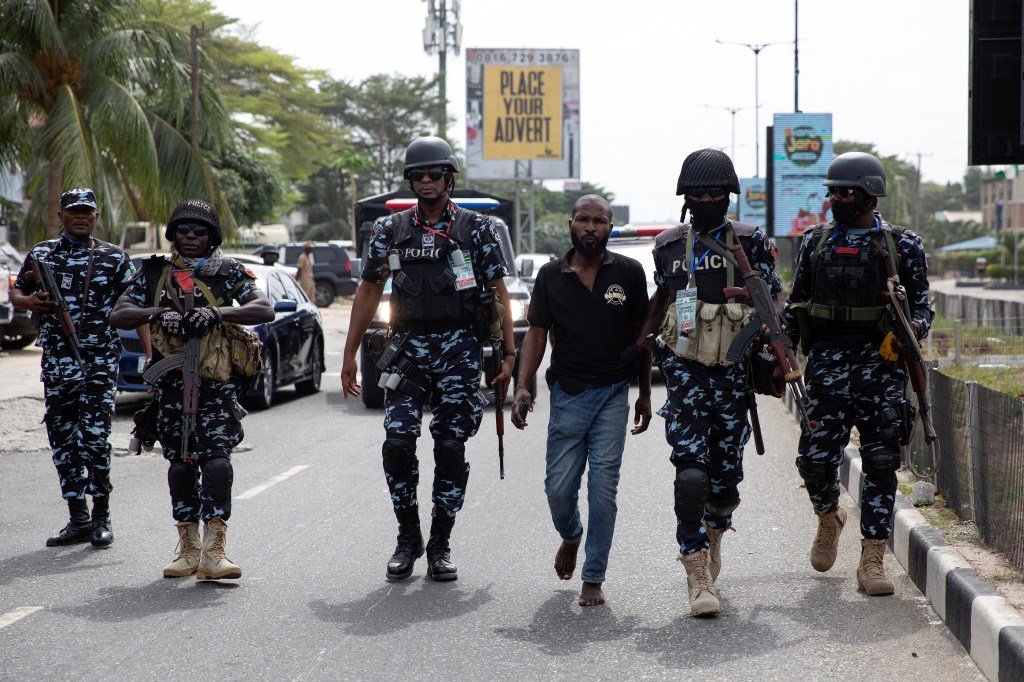 Police officers detain a man on suspicion of voter intimidation outside a polling unit in Lekki, Lagos, Nigeria February 25, 2023.