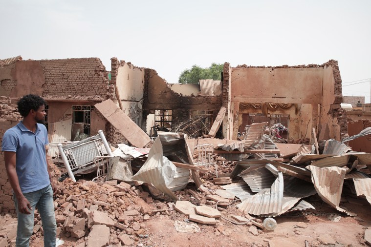 A man walks by a house hit by fighting in Khartoum, Sudan, on April 25, 2023.