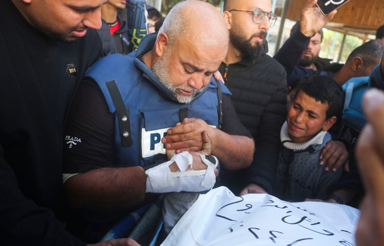 Al-Jazeera journalist Wael Al Dahdouh holds the hand of his son Hamza, who also worked for Al-Jazeera and who was killed in an Israeli strike in southern Gaza on January 7, 2024.