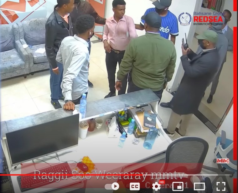 Reporter Mohamed Abdi Abdullahi (center) is surrounded by plain-clothed, intelligence agents during a raid on MM Somali TV's office in Hargeisa on January 6, 2024. They interrupted a live debate and arrested the show's host, Mohamed Abdi Sheikh.