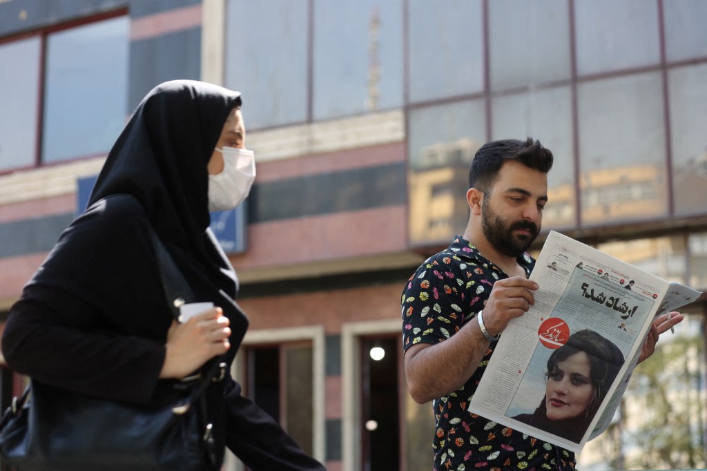 A man reads a newspaper with a picture of Mahsa Amini, who died after being arrested by morality police, in Tehran, Iran, on September 18, 2022.