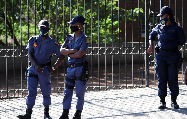 Police officers stand outside a court in Free State province, South Africa, on November 13, 2020.