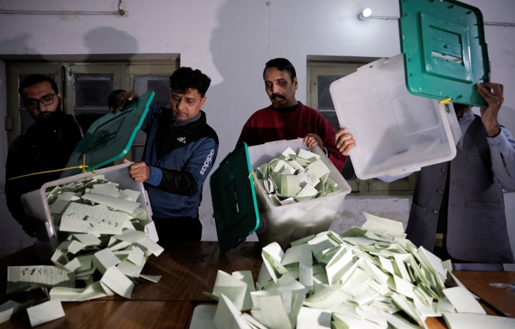 Polling station staff empty a ballot box after polls closed during the general election, in Lahore, Pakistan, on February 8, 2024.