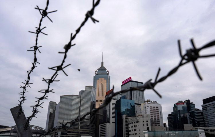 A Hong Kong cityscape is pictured in March 2024 through barbed wire.