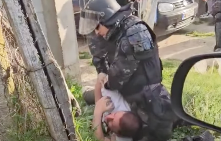 A police officer holds journalist Furkan Saliu down on the ground at a soccer game in Gorno Konjare in North Macedonia on April 7.