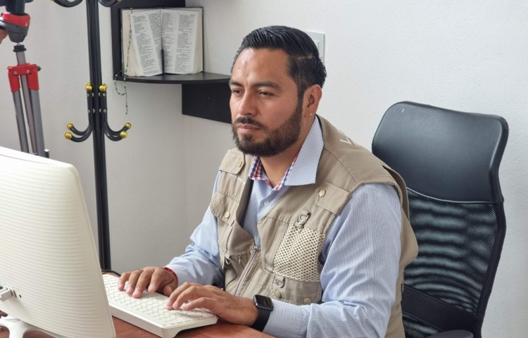 A man types on a computer at a desk.