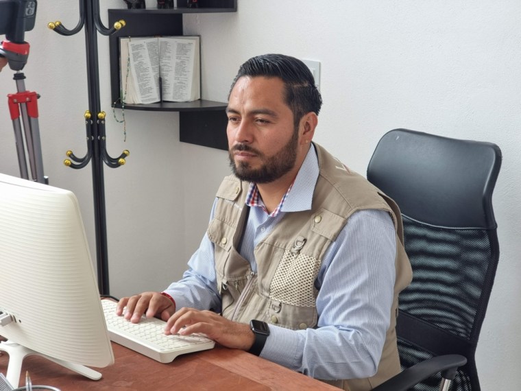 A man types on a computer at a desk.