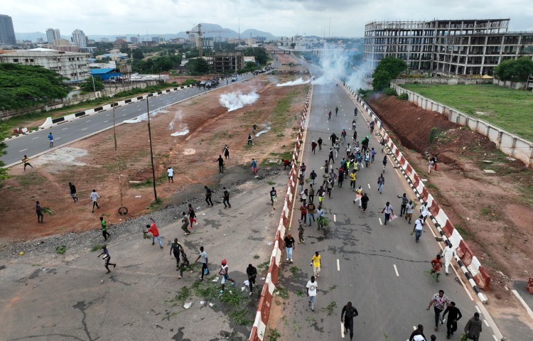 Protestors running from clouds of tear gas fired by Nigerian security forces during the End Bad Governance protests in the capital Abuja on August 2.