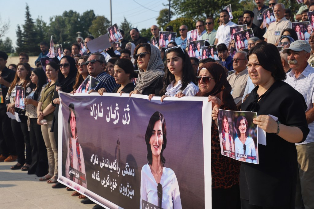 Protesters lift portraits of slain journalists Hero Bahadin (left) and Gulistan Tara in Sulaimaniya, Iraqi Kurdistan, on August 24, 2024.