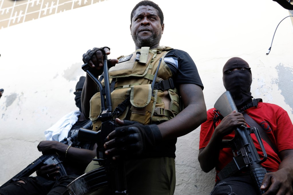 Jimmy Chérizier, a former elite police officer who now runs a gang federation, stands with his gang members in Port-au-Prince, Haiti, in March 2024.