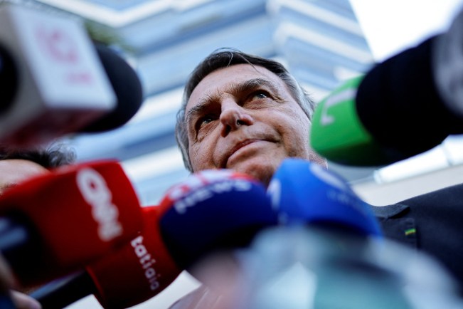 Former Brazilian President Jair Bolsonaro speaks with the media as he leaves the Federal Police headquarters after testifying about the January 8 riots, in Brasilia, Brazil, October 18, 2023. (Photo: Reuters/Ueslei Marcelino)