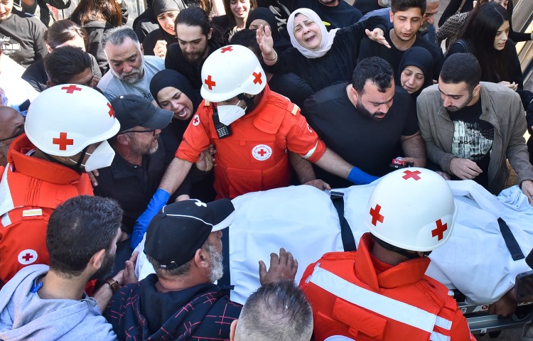Relatives and colleagues of three journalists killed in an Israeli strike in southern Lebanon on October 25, 2024, gather around a Red Cross ambulance as their bodies arrive at a hospital in Beirut. (Photo: AFP/Fadel Itani)