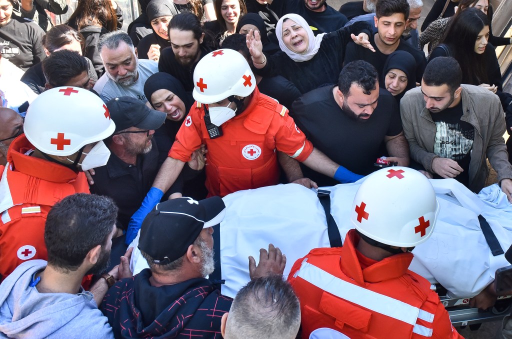 Relatives and colleagues of three journalists killed in an Israeli strike in southern Lebanon on October 25, 2024, gather around a Red Cross ambulance as their bodies arrive at a hospital in Beirut. (Photo: AFP/Fadel Itani)