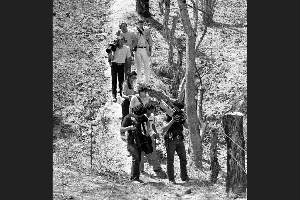 In this March 18, 1982 photo, television cameramen photograph blood-soaked, bullet-ridden clothes believed to belong to four Dutch journalists killed in a wooded area near this village in the province of Chalatenango, in El Salvador. Jan Kuiper, Koos Koster, Hans ter Laag and Joop Willemsen were killed in 1982 while on assignment for IKON, a Dutch public TV broadcaster. (AP Photo/P.W. Hamilton)