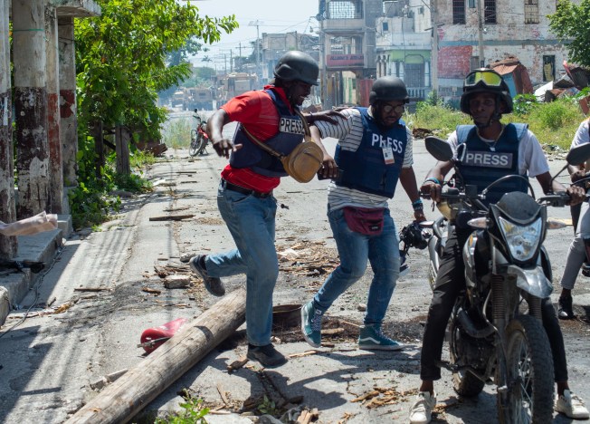 A journalist's driver injured by tear gas is evacuated near the national palace in Port-au-Prince, Haiti, July 17, 2024. The Caribbean nation became the likeliest nation to let journalists' murderers go free in CPJ's 2024 Global Impunity Index. (Photo: AFP/Clarens Siffroy)