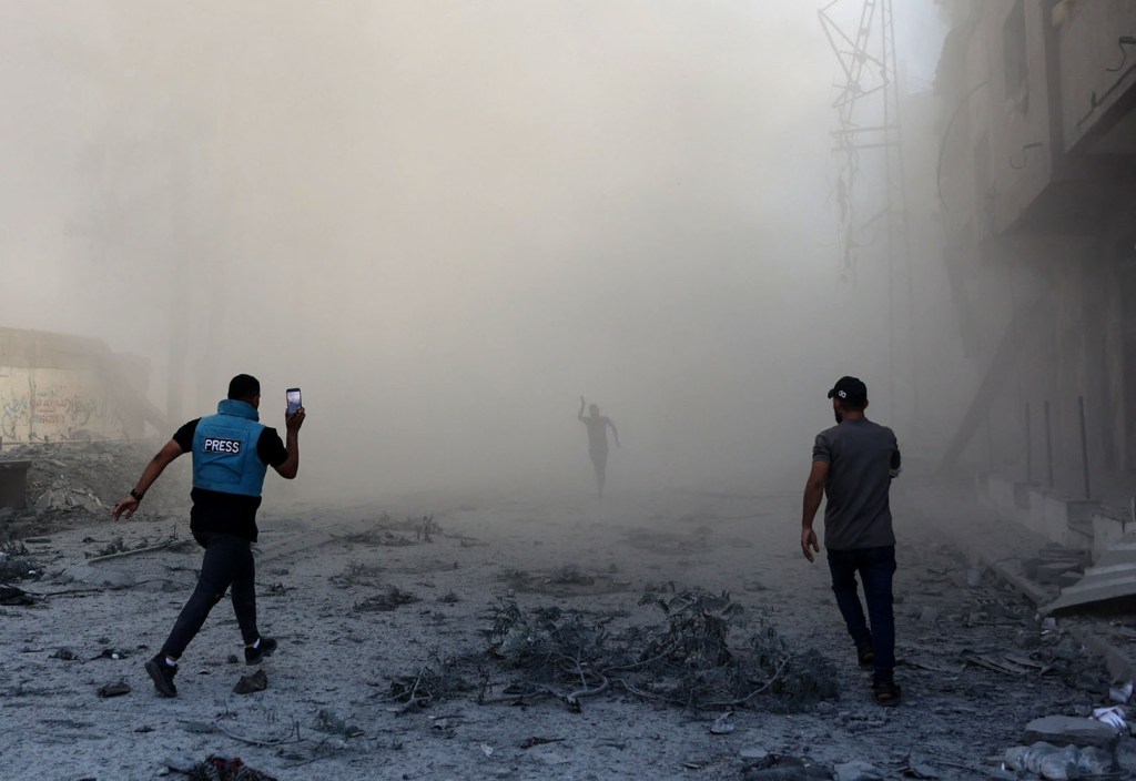 A journalist and others rush toward the scene of an explosion following an Israeli strike on the outskirts of Gaza City, on September 1, 2024. (Photo: AFP/Omar Al-Qattaa)