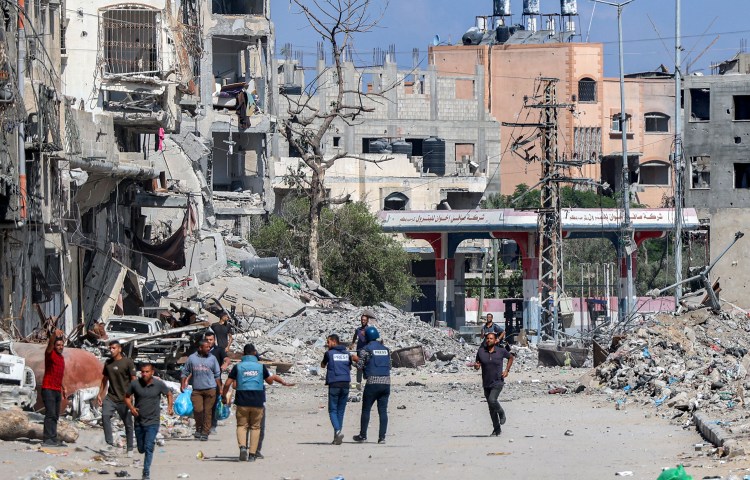 Journalists film while standing before destroyed buildings in the Jabalia camp for Palestinian refugees in the northern Gaza on October 9, 2024. (Photo: AFP/Omar Al-Qattaa)