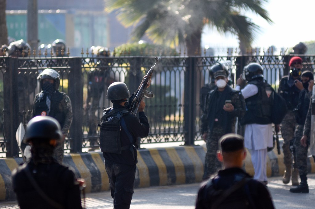 A police officer fires warning shots in the air during clashes with supporters of imprisoned former Prime Minister Imran Khan's Tehreek-e-Insaf party in Islamabad, Pakistan, on November 26, 2024. (Photo: AP/W.K. Yousufzai)