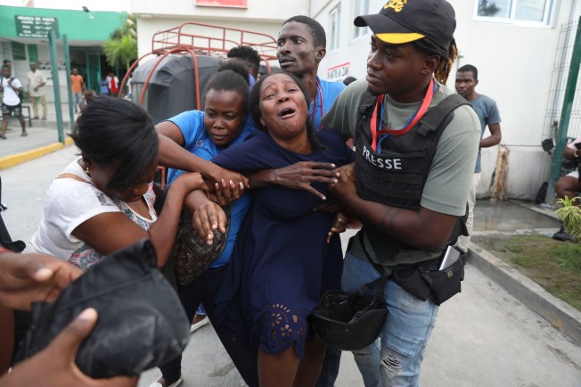 A woman identified as the wife of one of the journalists killed during an armed gang attack on the Haiti’s General Hospital cries as an ambulance arrives with his body at another hospital in Port-au-Prince on December 24, 2024. (Photo: AP/Odelyn Joseph)