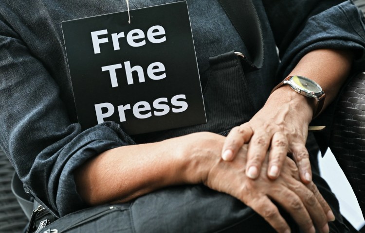 A member of the media wears a placard during an October 4, 2023, demonstration in New Delhi over the arrests of people linked to a news website. In 2024, CPJ provided prison support grants to 58 journalists jailed in connection with their work. (Photo: Arun Sankar/AFP)