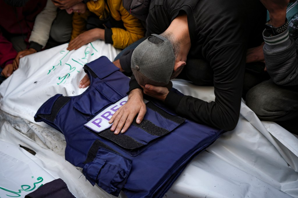 A relative mourns over the body of one of five Palestinian journalists killed by an Israeli airstrike in Gaza City's Al-Aqsa Hospital on December 26, 2024.