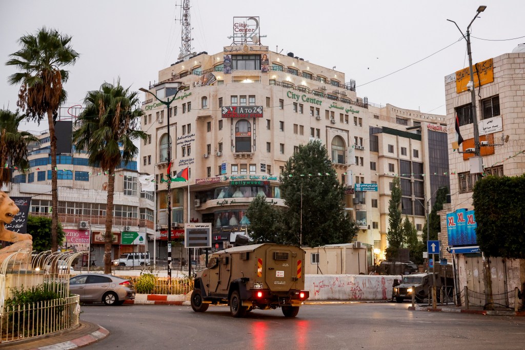 A military vehicle moves in a street outside the building where the Al Jazeera office is located, in Ramallah, in the Israeli-occupied West Bank, September 22, 2024. REUTERS/Mohammed Torokman - RC2F5AA82Z43