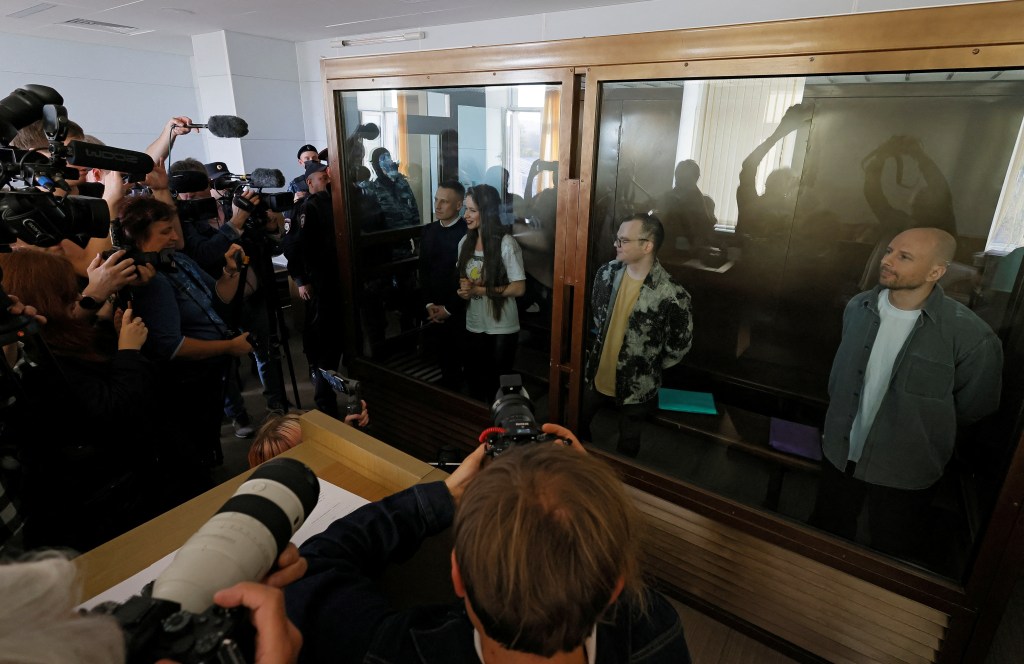 Journalists Konstantin Gabov, Antonina Favorskaya, Artem Kriger and Sergei Karelin, accused of taking part in the activities of an "extremist" organization founded by late opposition politician Alexei Navalny, stand inside an enclosure for defendants before a court hearing in Moscow, Russia October 2, 2024