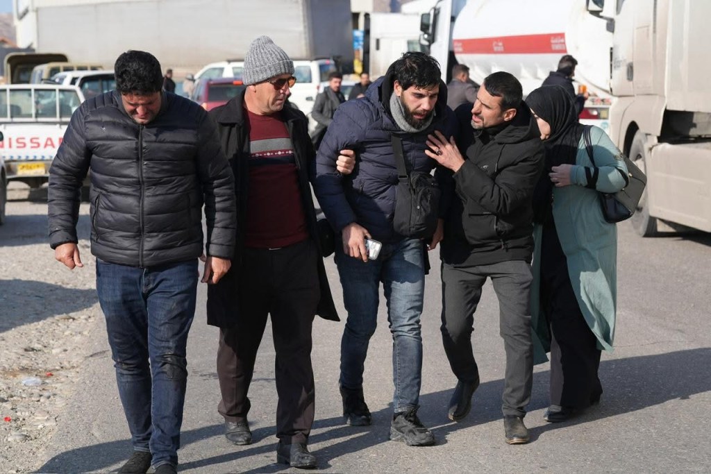 Camera operator Sivar Baban (third from left) is helped to walk after being teargassed.