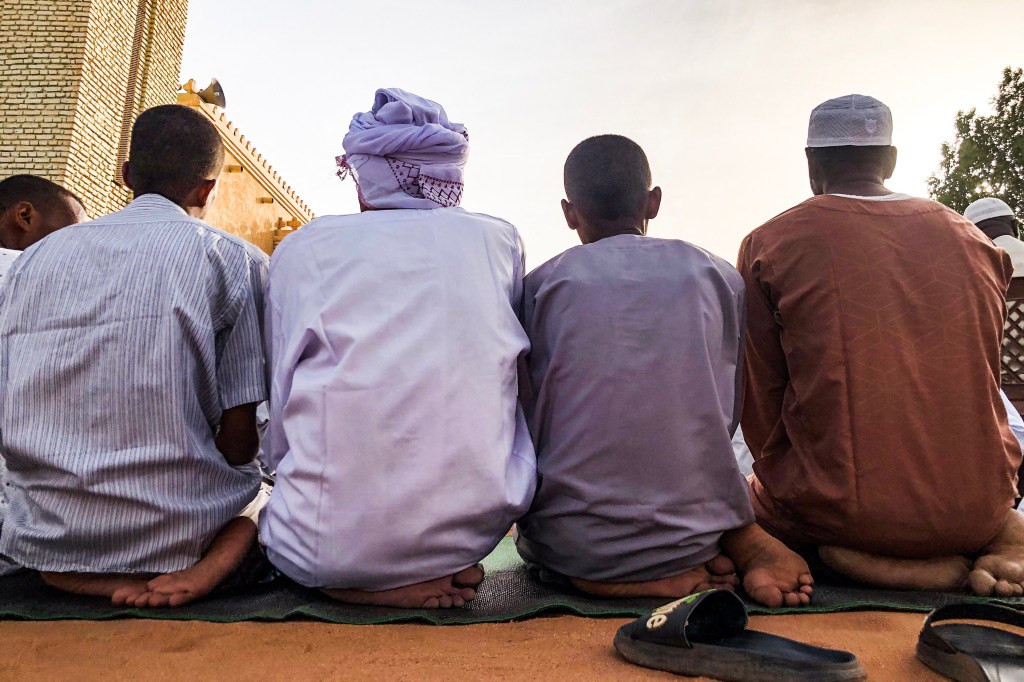Sudanese men perform the morning prayer in front of a mosque in Omdurman, on the first day of the holiday marking the end of the hajj pilgrimage to Mecca, in June 2024. Blogger Abduljalil Mohamed Abduljalil was arrested on May 25, 2025, in connection with his reporting on the Sudan's pilgrimage authority. (Photo: AFP)